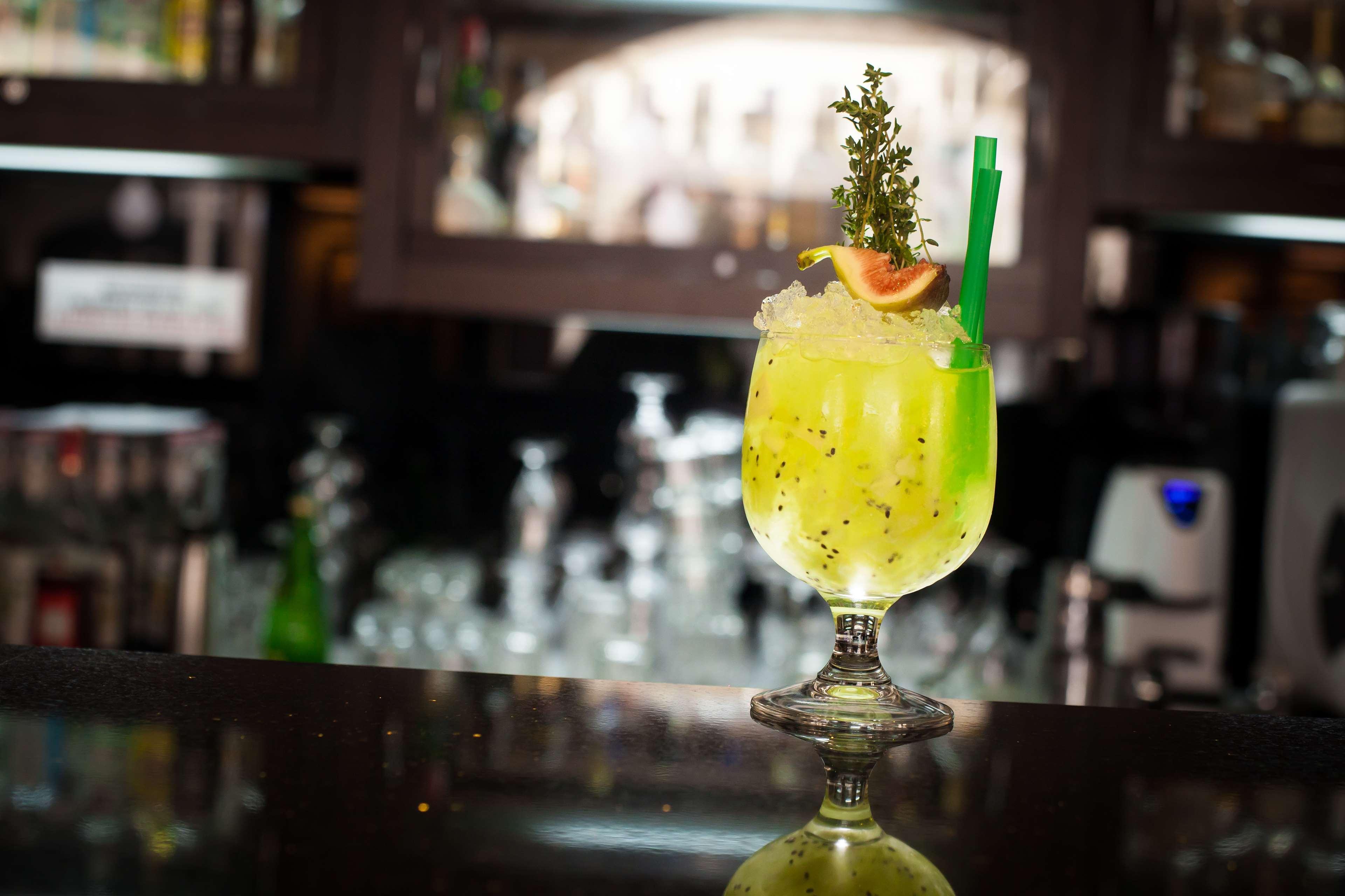 Radisson Blu Hotel, Gdansk Bagian luar foto The photo shows a vibrant, green cocktail served in a stylish glass with a wide base and an elegant stem. The drink is garnished with a slice of fruit and a sprig of herbs, adding visual appeal. A green straw is inserted into the drink, and it appear